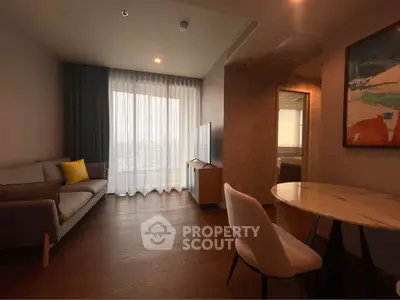 Modern living room with cozy sofa, stylish decor, and large window for natural light.