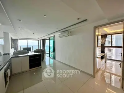 Spacious modern living room with open kitchen and large windows offering stunning views.