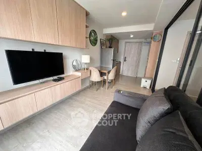 Modern living room with sleek furniture and mounted TV in stylish apartment.