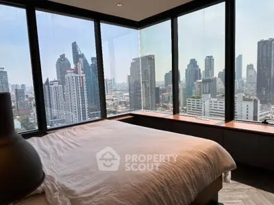 Luxurious bedroom with panoramic city skyline view from floor-to-ceiling windows.