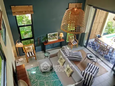 Stunning open-plan living room with tropical decor and poolside view, perfect for relaxation and entertaining.