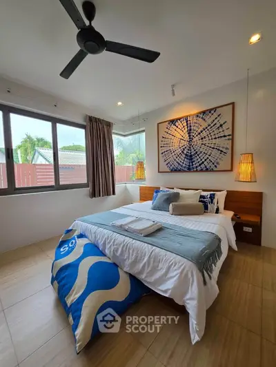 Modern bedroom with stylish decor and large window offering natural light