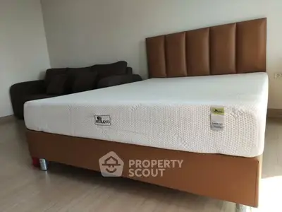 Spacious bedroom with modern bed and cozy sofa, perfect for relaxation.