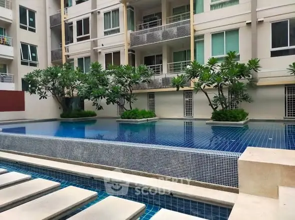 Luxurious condominium with serene pool and lush greenery