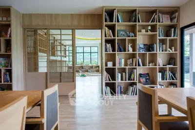 Spacious modern living room with wooden bookshelves and sliding doors, offering a cozy and inviting atmosphere.