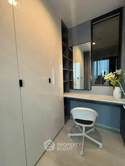 Modern study room with sleek desk, chair, and built-in storage in a stylish apartment.