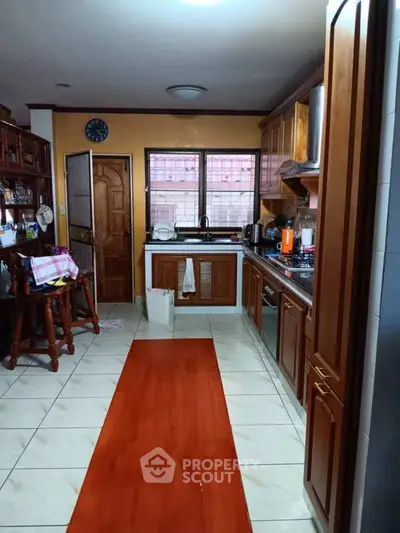 Charming kitchen with wooden cabinets and open layout, featuring modern appliances and a cozy dining area.