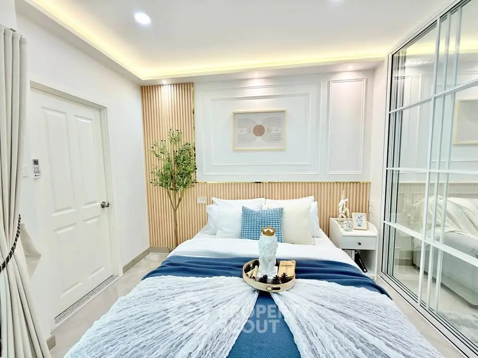 Luxurious bedroom with elegant decor and ambient lighting, featuring a cozy bed and stylish wall accents.