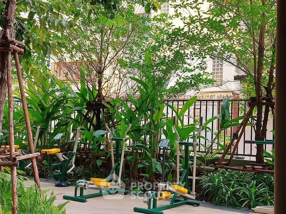 Outdoor gym area surrounded by lush greenery in a residential complex.