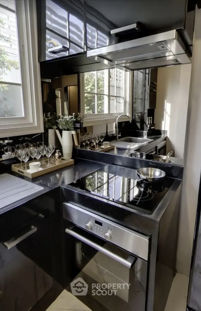 Modern kitchen with sleek black cabinetry and stainless steel appliances.
