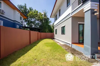 Modern two-story house with spacious backyard and lush green lawn