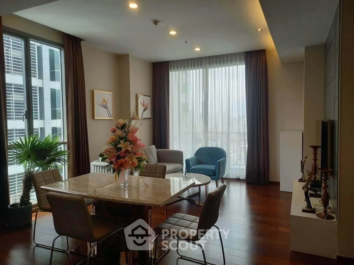 Spacious modern living room with elegant decor and large windows offering natural light.