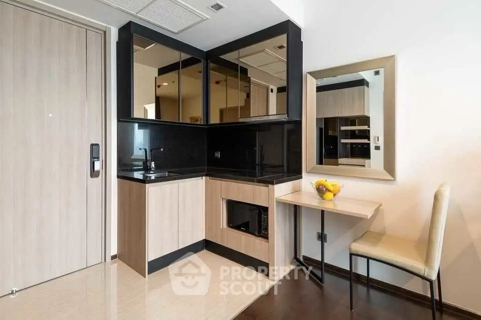 Modern compact kitchen with sleek black countertops and integrated appliances