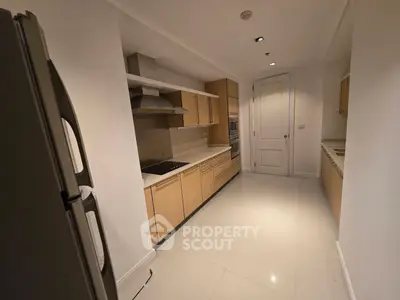 Spacious modern kitchen with sleek cabinetry and built-in appliances in a luxury apartment.