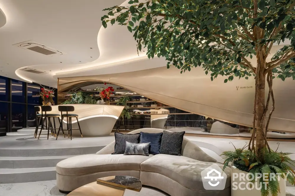 Luxurious open-plan living space with modern curved sofa, elegant lighting, and indoor greenery, perfect for upscale urban living.