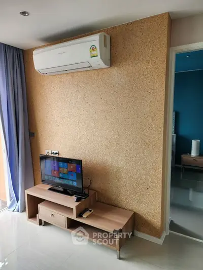 Modern living room with air conditioning and sleek TV setup in a stylish apartment.