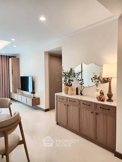 Elegant living room with modern decor and stylish furniture, featuring a sleek TV unit and decorative accents.