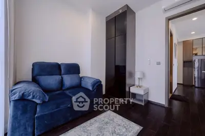 Modern living room with blue sofa and sleek dark wood flooring