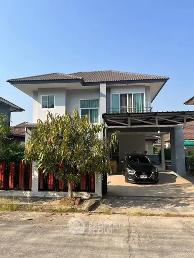 Charming two-story house with carport and lush garden in suburban neighborhood.