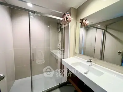 Modern bathroom with glass shower enclosure and sleek vanity