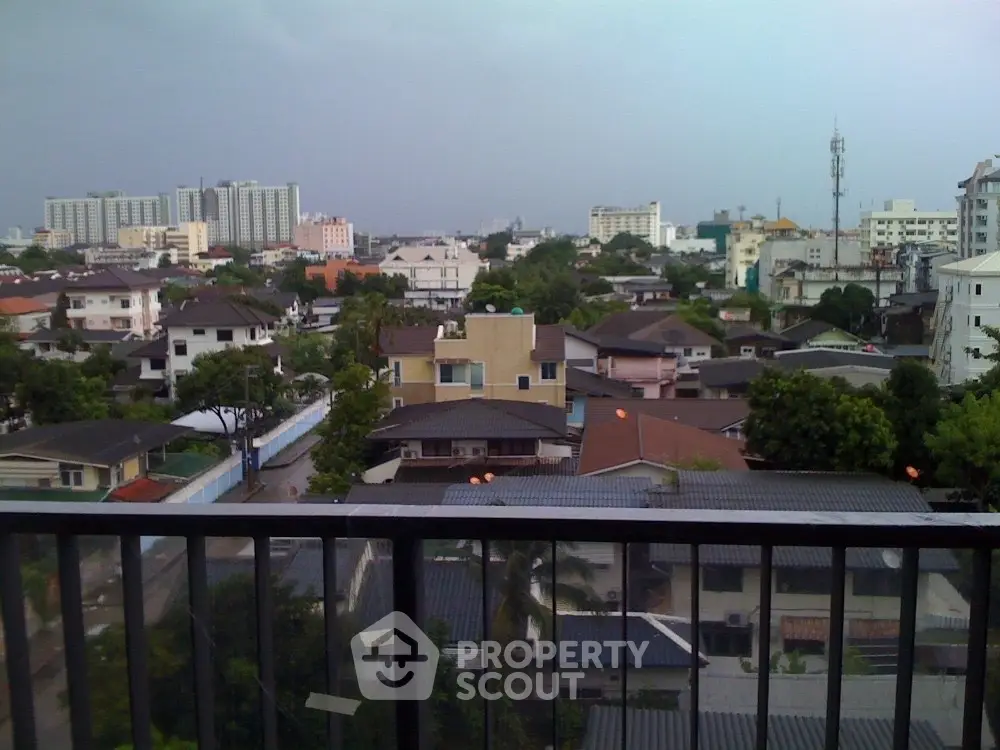 Stunning cityscape view from a balcony overlooking urban residential area with lush greenery.