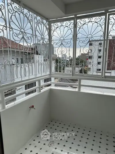 Charming balcony with decorative ironwork and city view, perfect for relaxation.