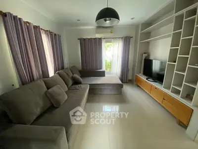 Spacious living room with modern sofa and entertainment center, perfect for relaxation and entertainment.