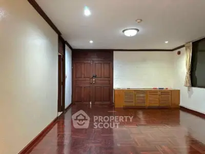 Spacious living room with wooden flooring and elegant wall paneling