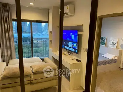Modern living room with city view, featuring cozy sofa and wall-mounted TV, adjacent to a stylish bedroom.