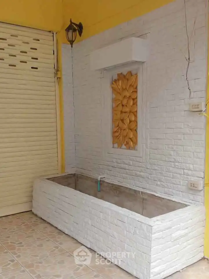 Charming exterior corner with decorative wall art and planter box.