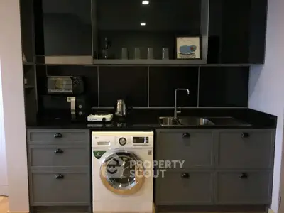 Modern kitchen with sleek black cabinetry and built-in washing machine