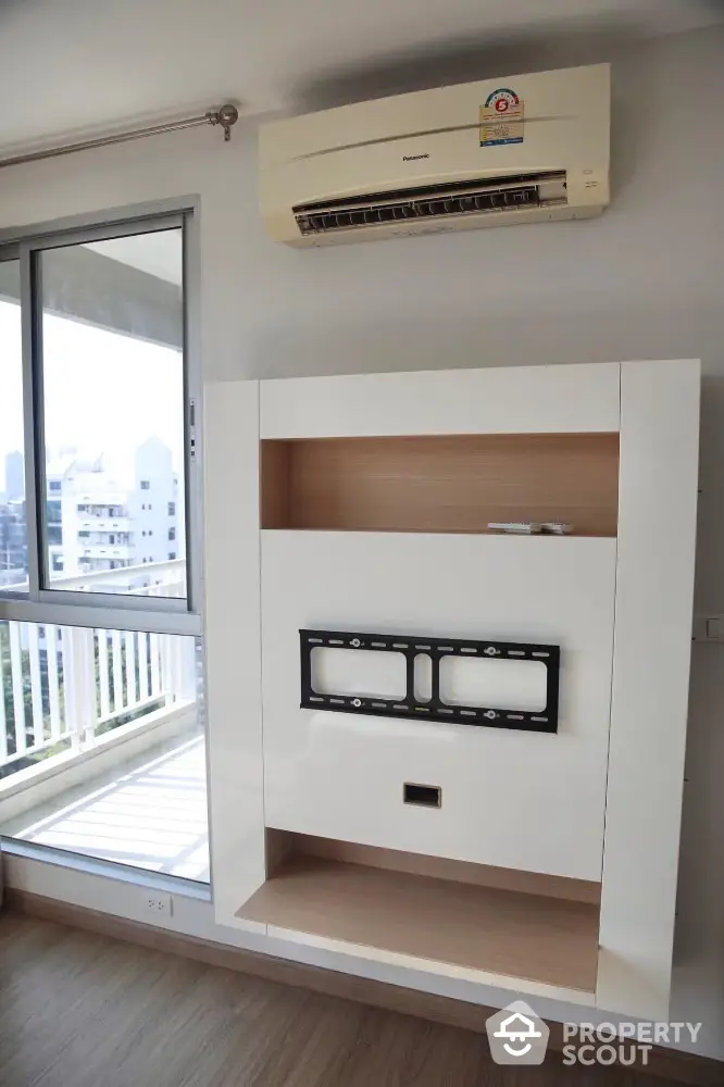 Modern apartment interior with air conditioning and TV mount near balcony