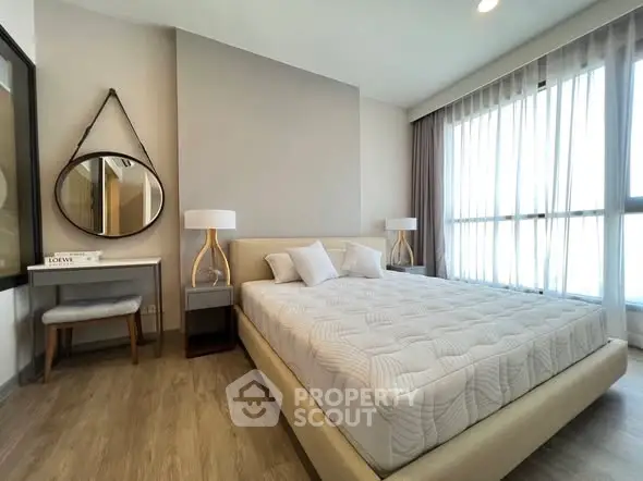 Modern bedroom with stylish decor, large window, and elegant furnishings in a contemporary apartment.
