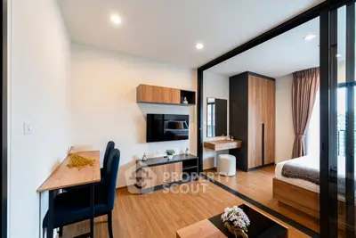 Modern bedroom with wooden flooring, stylish furniture, and a cozy workspace.