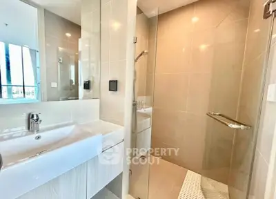 Modern bathroom with sleek design and glass shower enclosure in a contemporary apartment.