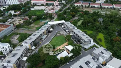 Aerial view of modern residential complex with lush greenery and spacious layout.