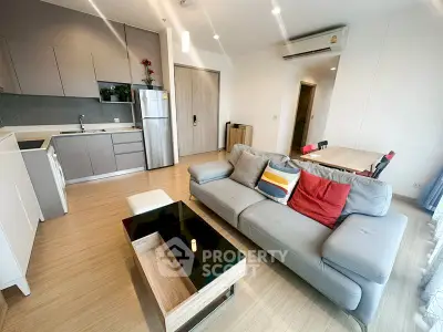 Modern open-plan living room with sleek kitchen and cozy seating area.