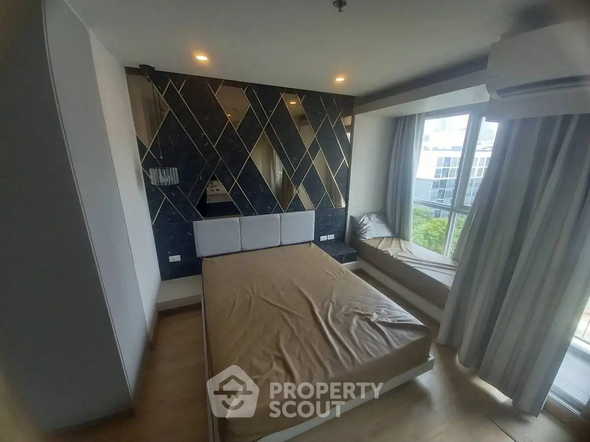 Modern bedroom with stylish accent wall and large window seating area