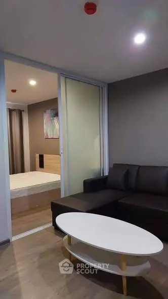 Modern living room with sleek furniture and sliding door to bedroom