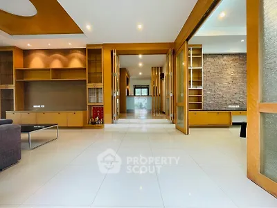 Spacious modern living room with elegant wooden accents and ample natural light