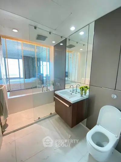 Modern bathroom with glass shower and sleek fixtures in luxury apartment.
