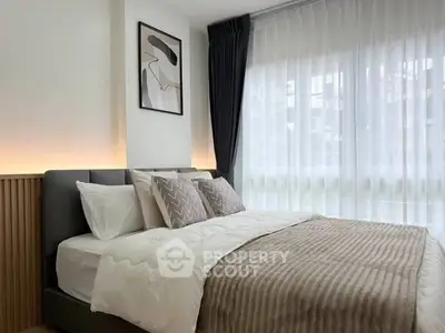 Modern bedroom with stylish decor and large window for natural light.
