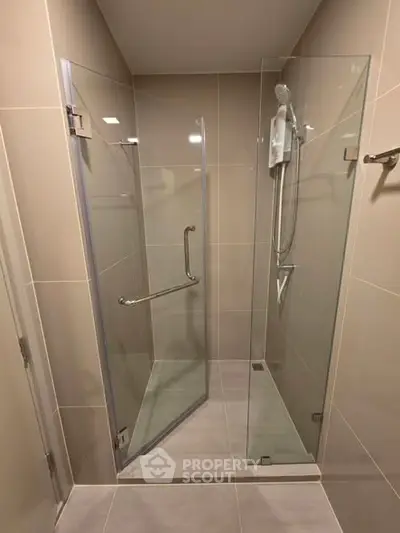 Modern bathroom with glass shower enclosure and sleek tile design.