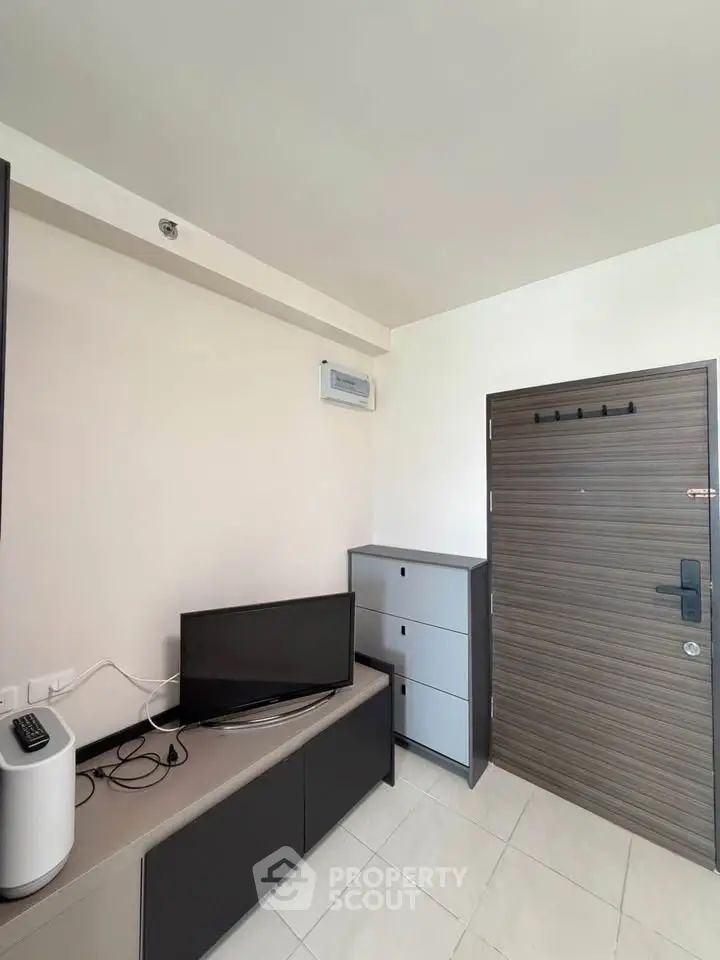 Modern living room with sleek furniture and wall-mounted TV, showcasing minimalist design.