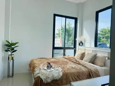 Cozy bedroom with large windows and stylish decor, perfect for relaxation.