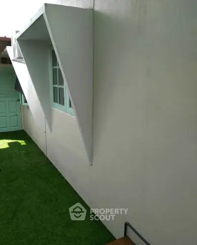Modern exterior with unique architectural design and artificial grass lawn.