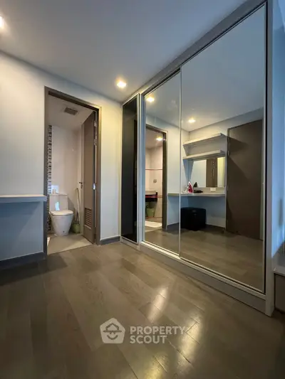 Spacious modern bedroom with mirrored closet and ensuite bathroom