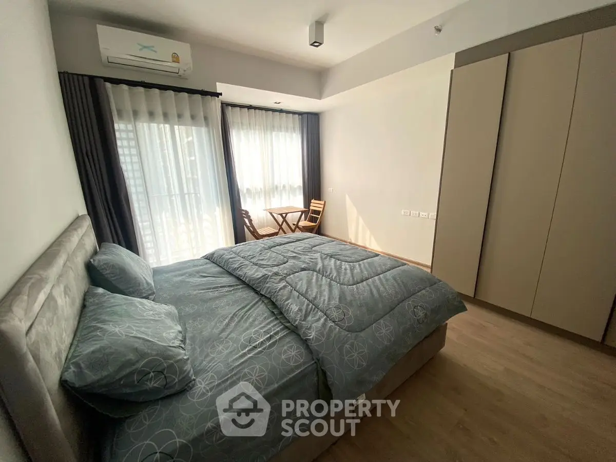 Spacious bedroom with natural light and modern furnishings