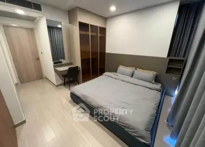 Modern bedroom with sleek design, featuring a comfortable bed, built-in wardrobe, and stylish desk area.