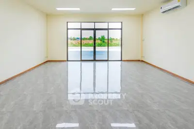 Spacious empty room with large windows and glossy tiled floor